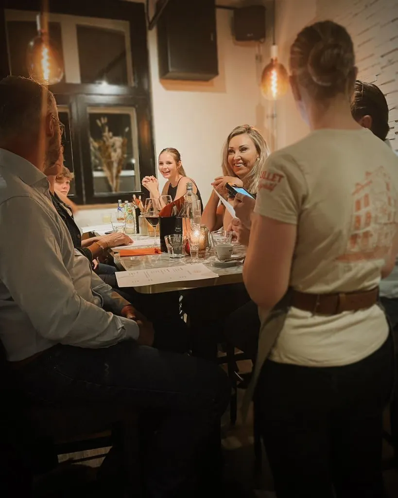 Un membre de l’équipe de la Restobar LURE sert des clients à table