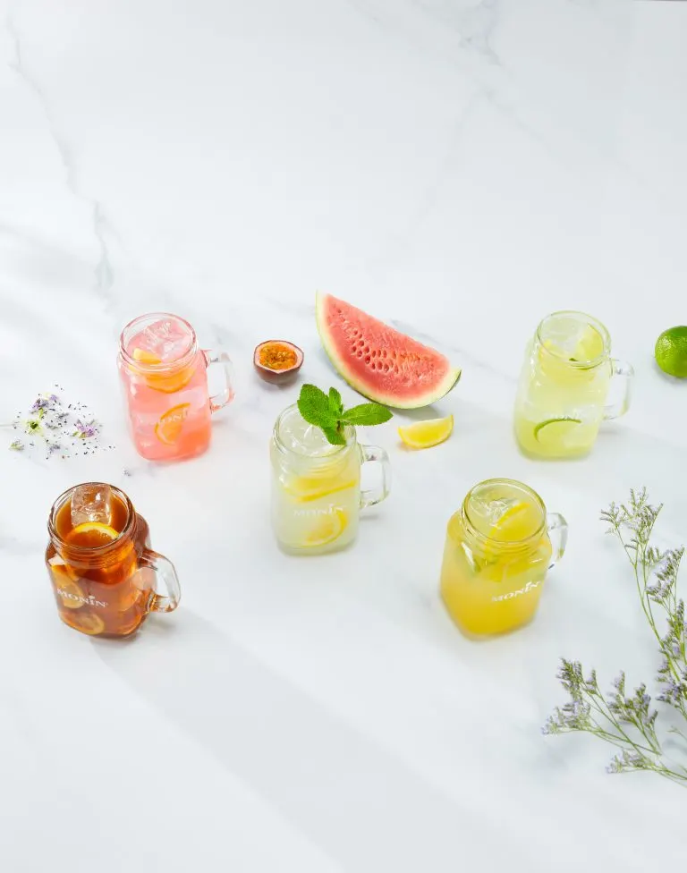 Homemade lemonades and iced teas in glass jars with fruit
