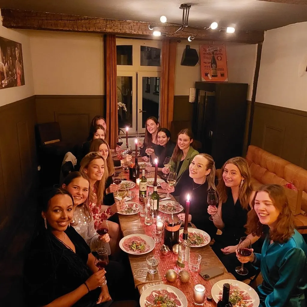 Eine Gruppe an einer langen Tafel bei Kerzenlicht im Restobar LURE