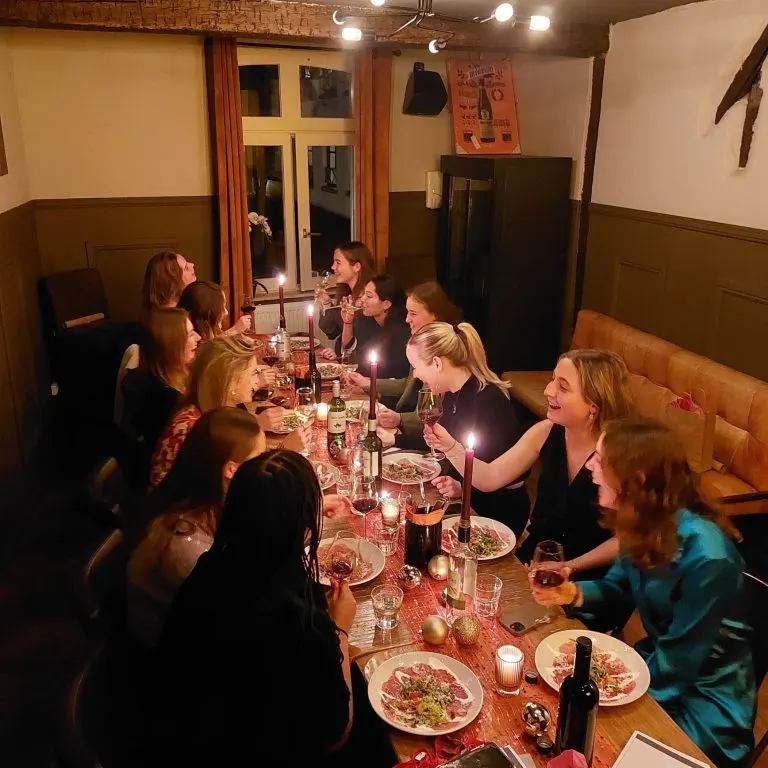 Table longue avec invités, bougies et plats lors d'un dîner privé chez LURE