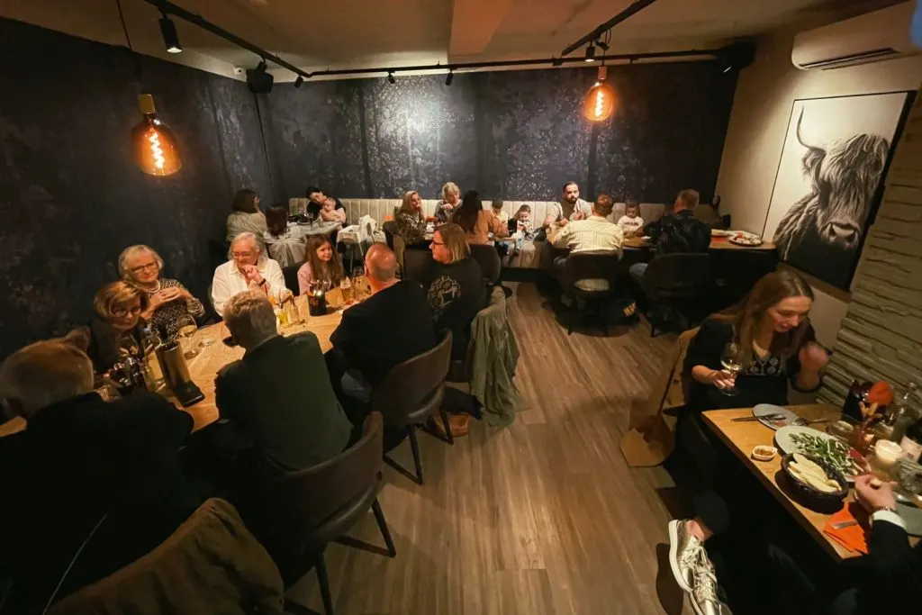 Un groupe aux longues tables à l’intérieur de la Restobar LURE